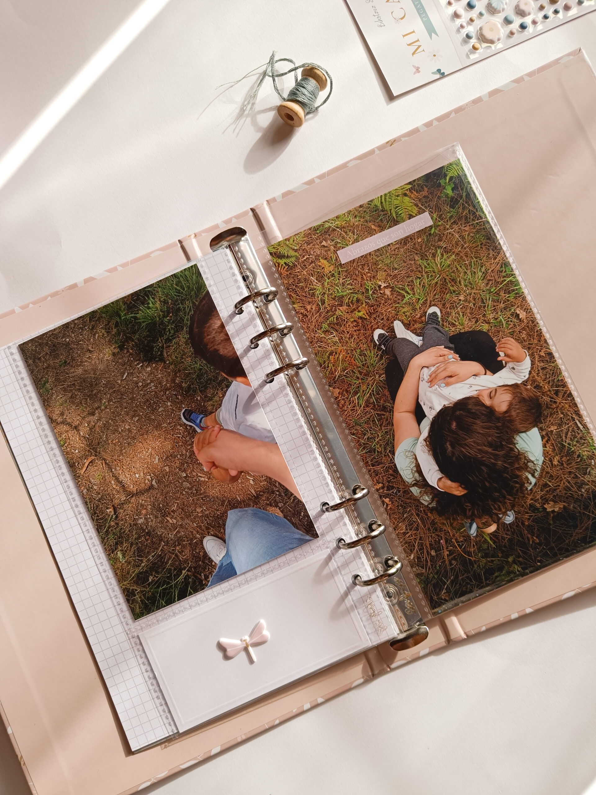 Páginas de scrapbooking en un álbum de anillas de 6 anillas decorado con bordado, vellum y sellos, perfecto para documentar recuerdos especiales.