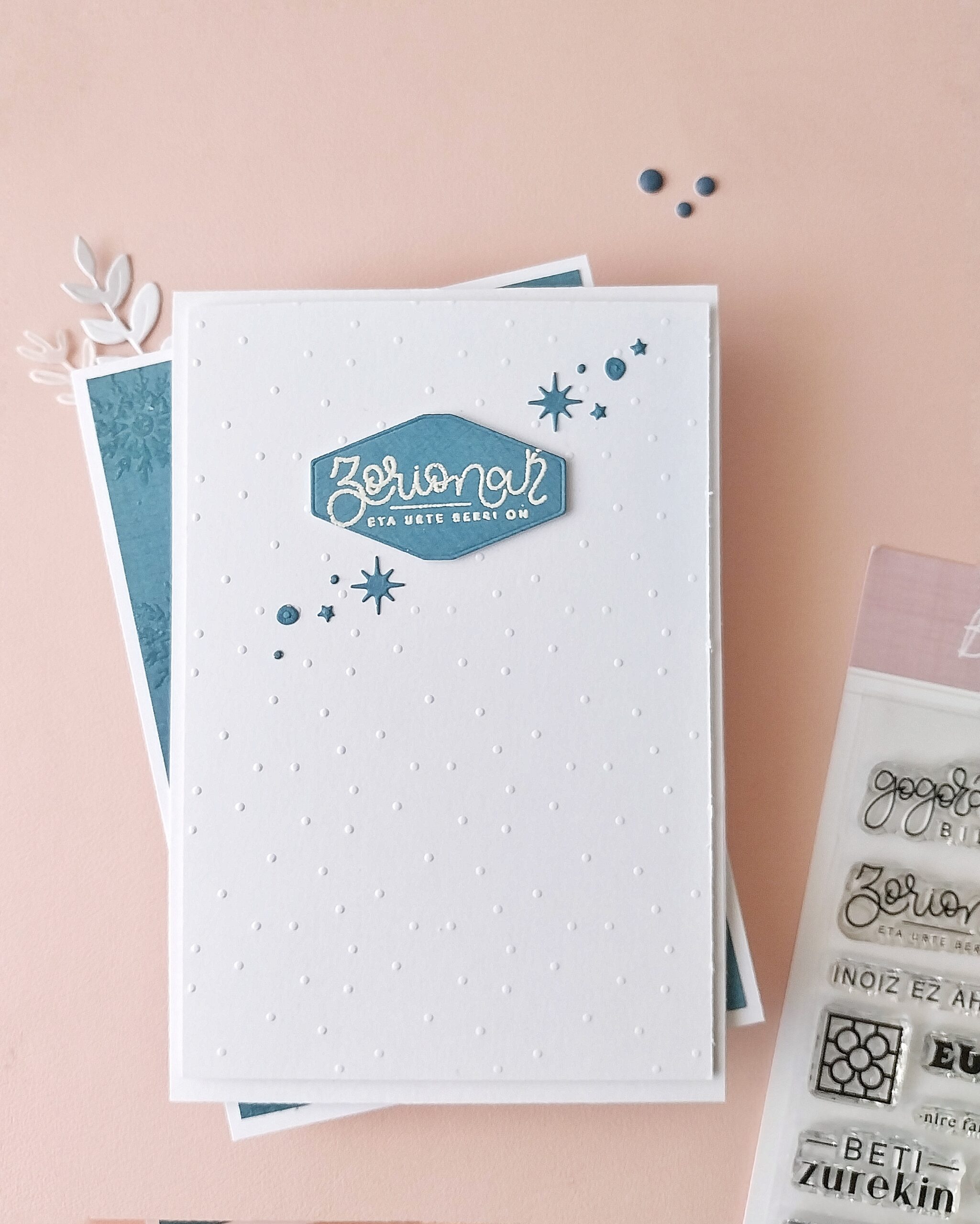 Postal de Navidad hecha con papeles básicos de Mi Calma, troquel Etiquetas y sello Bilbo, en tonos suaves y diseño minimalista.