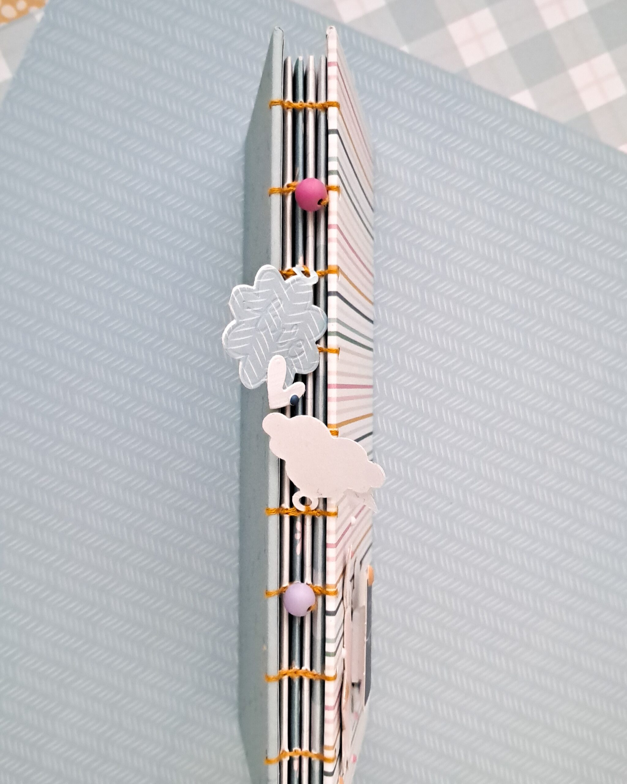 Lomo cosido decorado con charms en álbum scrapbooking