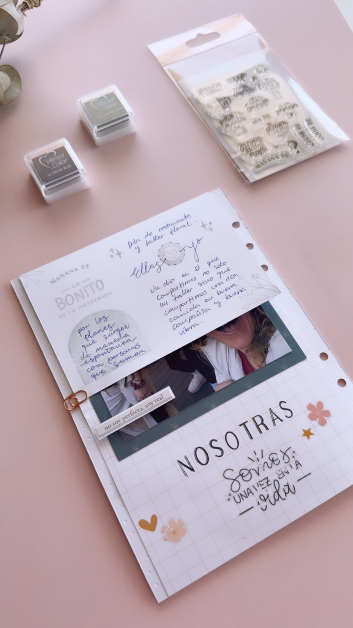 Capas decorativas con sellos y elementos de scrapbooking en una página de journal artesanal.