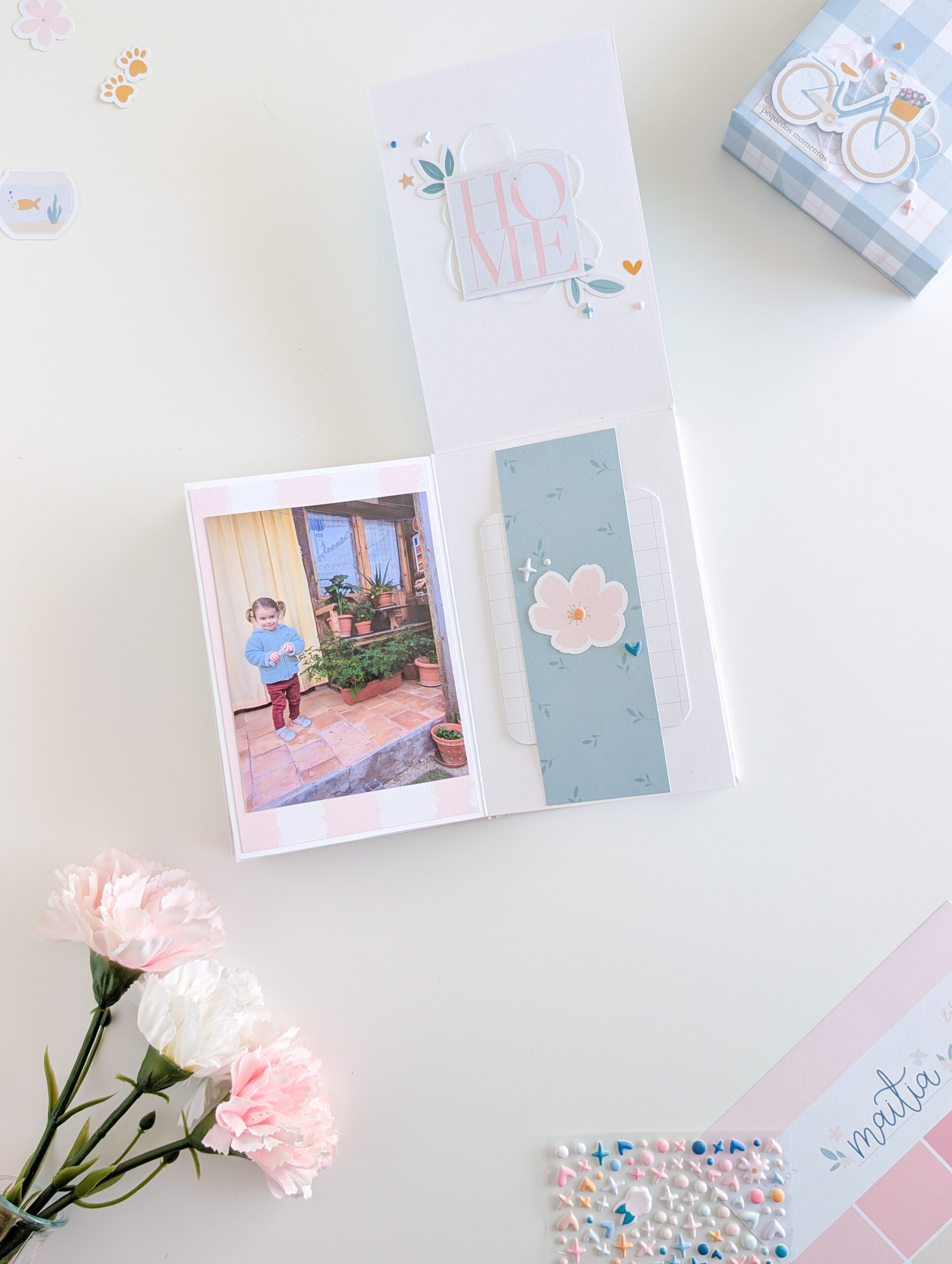 Detalle decorativo de mini álbum de scrapbooking con die cuts, puffies y rub-ons.